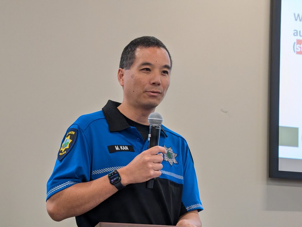 A man in a police uniform speaking into a microphone
