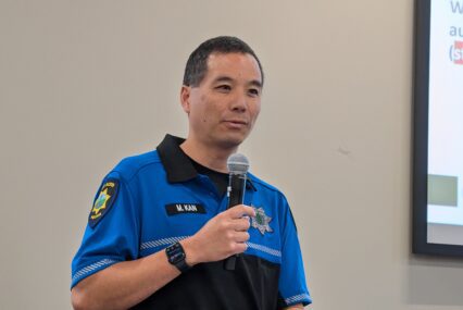 A man in a police uniform speaking into a microphone