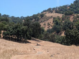 OPEN SPACE MEASURE A hiking trail along with trees and green hillsides south of San Jose, California