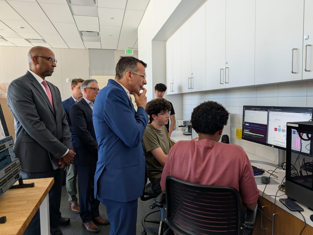 Man looking at students studying in a room.