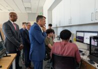 Man looking at students studying in a room.