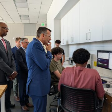 Man looking at students studying in a room.