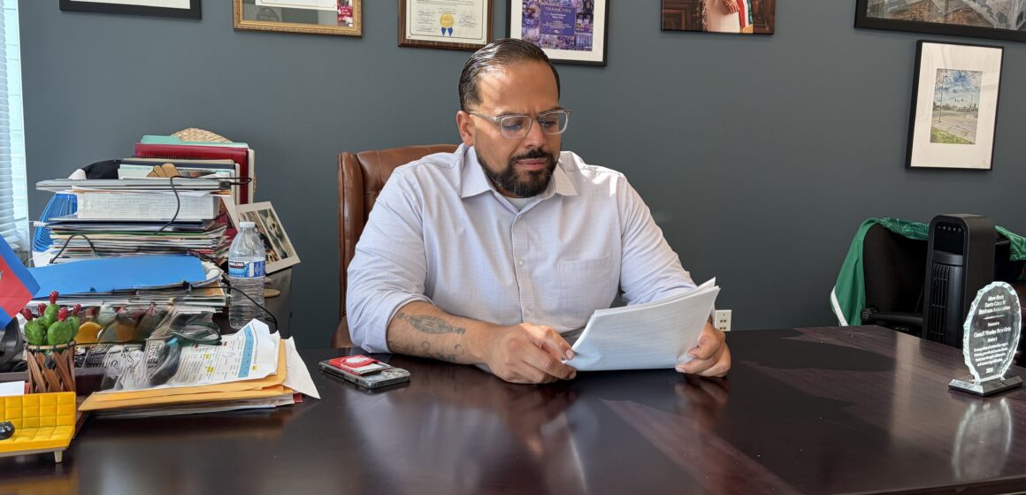 Peter Ortiz A man sitting at a desk looking at papers