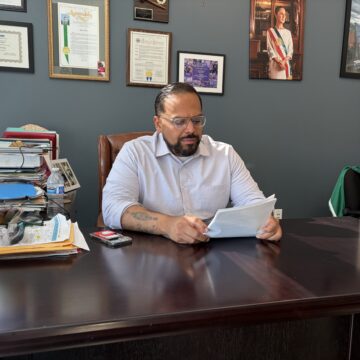 A man sitting at a desk looking at papers