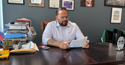 A man sitting at a desk looking at papers