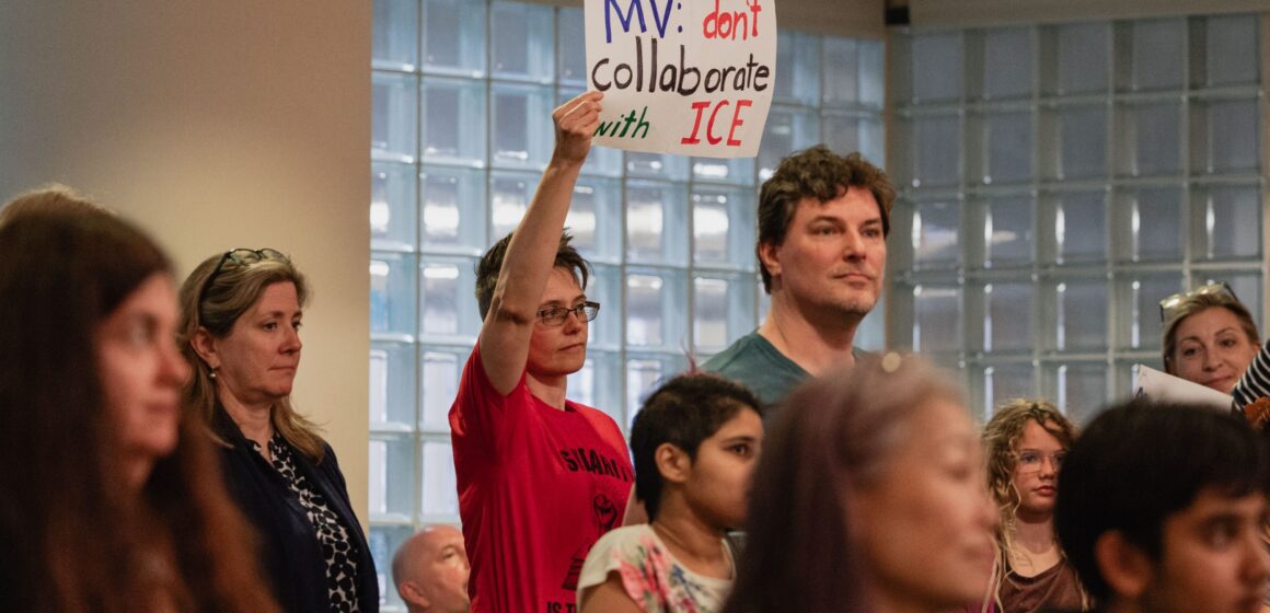 People at meeting holding up signs