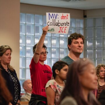 People at meeting holding up signs