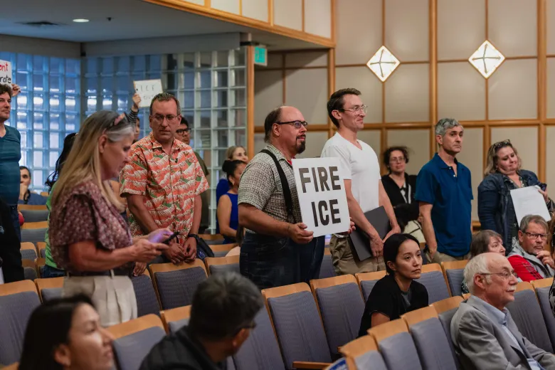 People at a meeting holding up signs