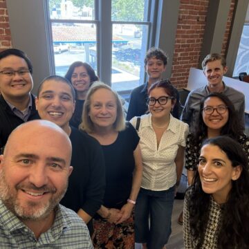 Spotlight team A group of people in an office posing for a selfie photo