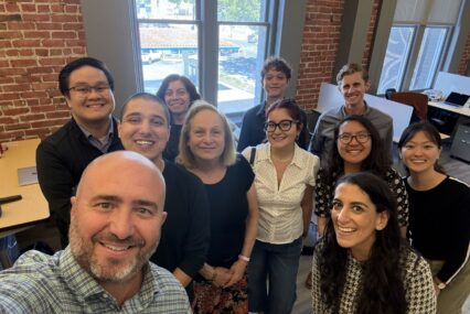 A group of people in an office posing for a selfie photo
