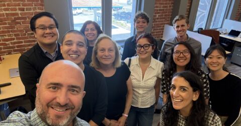 A group of people in an office posing for a selfie photo