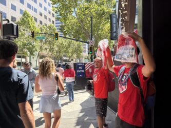 Downtown San Jose street vendors Two men selling soccer jerseys as people walk by in downtown San Jose, California