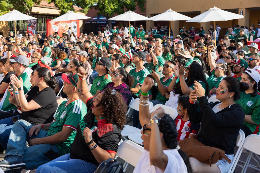 People sitting in chairs cheering during a World Cup watch party in San Jose, California