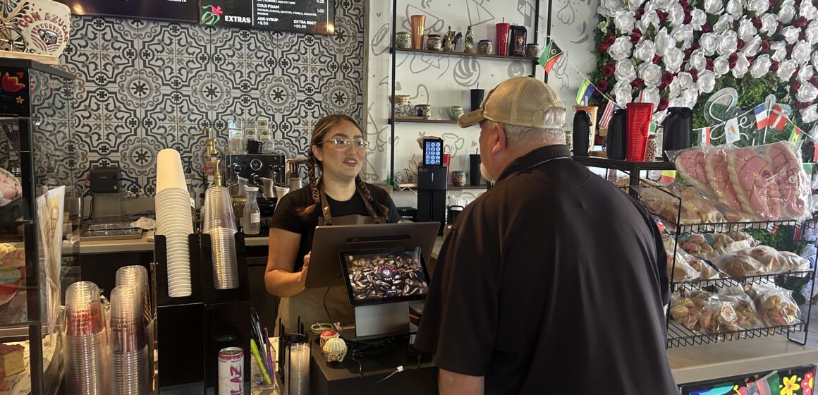 A barista behind a counter takes the order of a customer at a cafe in Gilroy, California