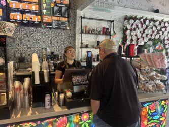 Con Azucar-Gilroy A barista behind a counter takes the order of a customer at a cafe in Gilroy, California