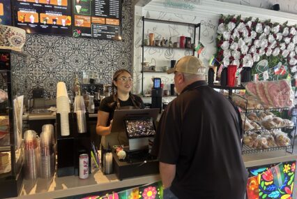 A barista behind a counter takes the order of a customer at a cafe in Gilroy, California