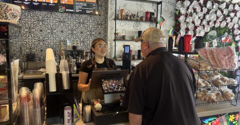 A barista behind a counter takes the order of a customer at a cafe in Gilroy, California