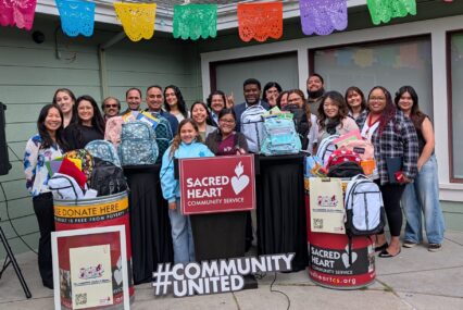 A group of people standing with backpacks full of school supplies to give to students in need