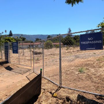 A chain link fence with a dirt road behind it in Saratoga, California