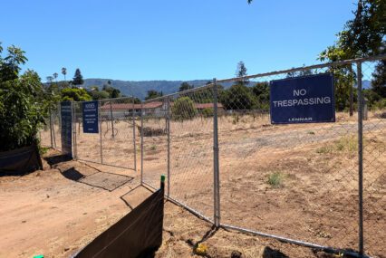 A chain link fence with a dirt road behind it in Saratoga, California