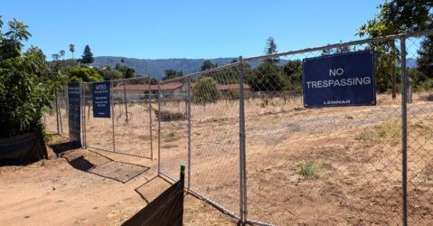 A chain link fence with a dirt road behind it in Saratoga, California