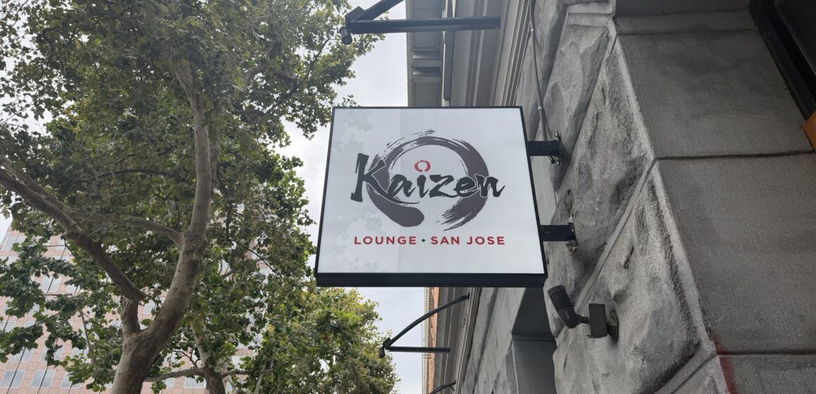 Kaizen Lounge on E San Fernando St. A sign on a stone building next to trees.