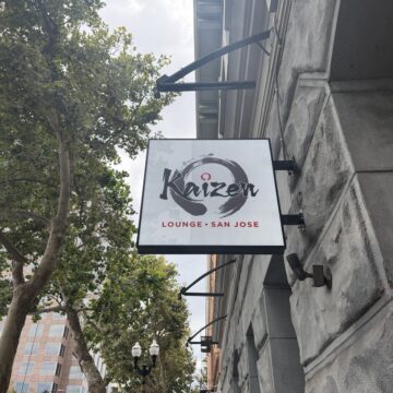 Kaizen Lounge on E San Fernando St. A sign on a stone building next to trees.