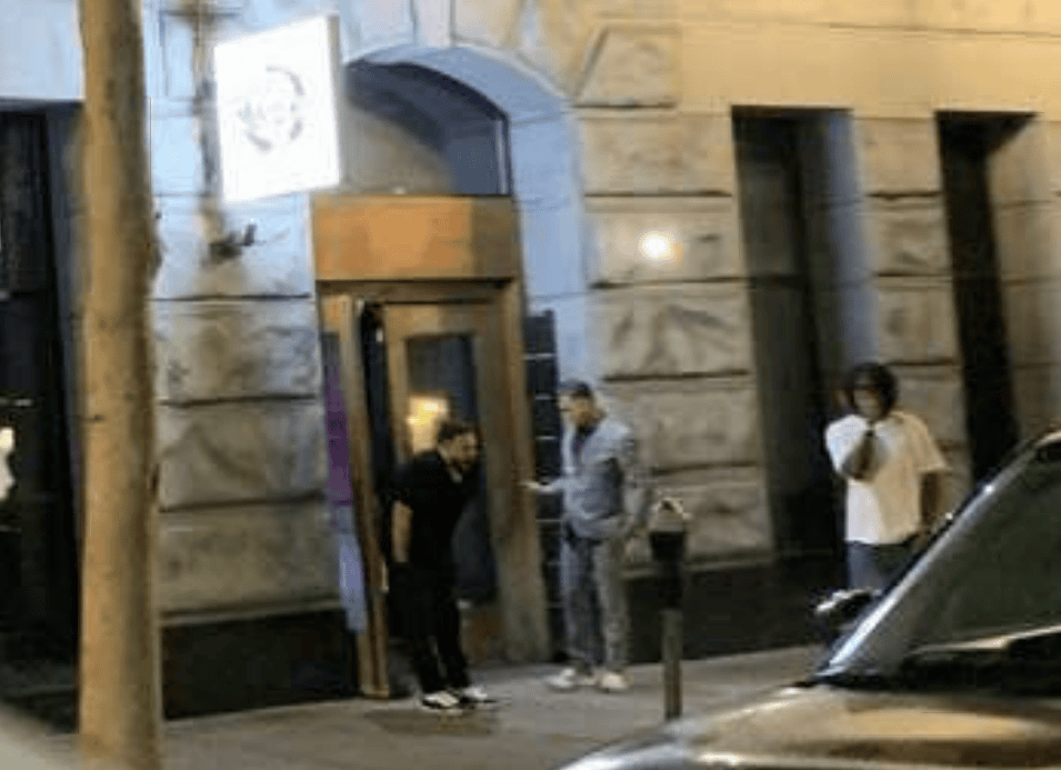 Three people stand in front of a building.