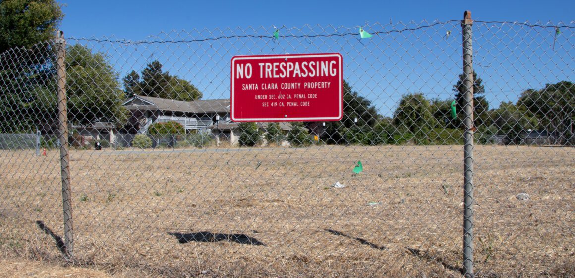 Santa Clara interim housing A chain link fence with a no trespassing sign in front of a vacant piece of land in Santa Clara, California