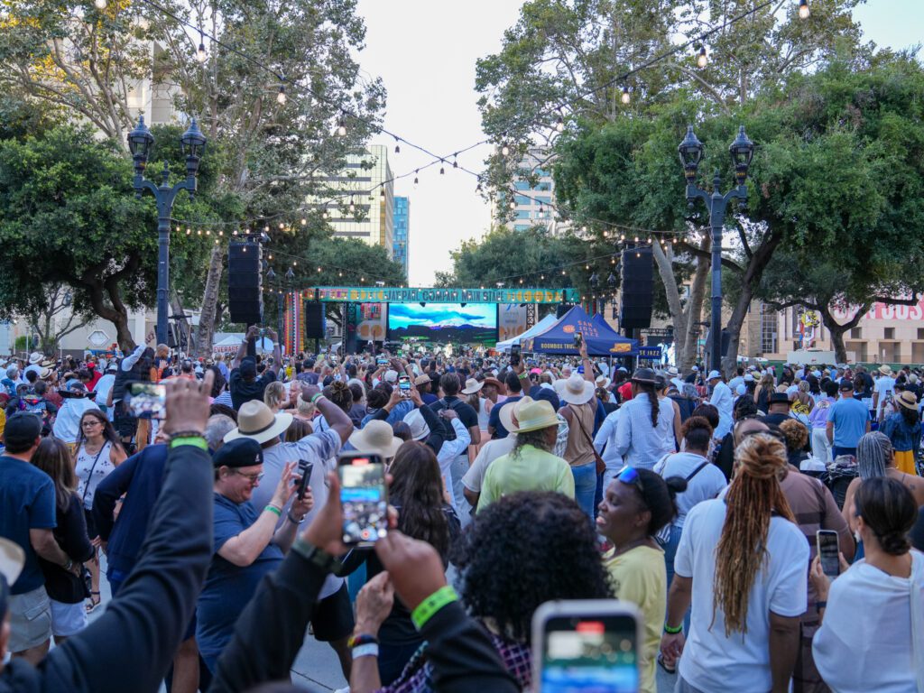 A crowd of people watching an outdoor music performance in San Jose, California
