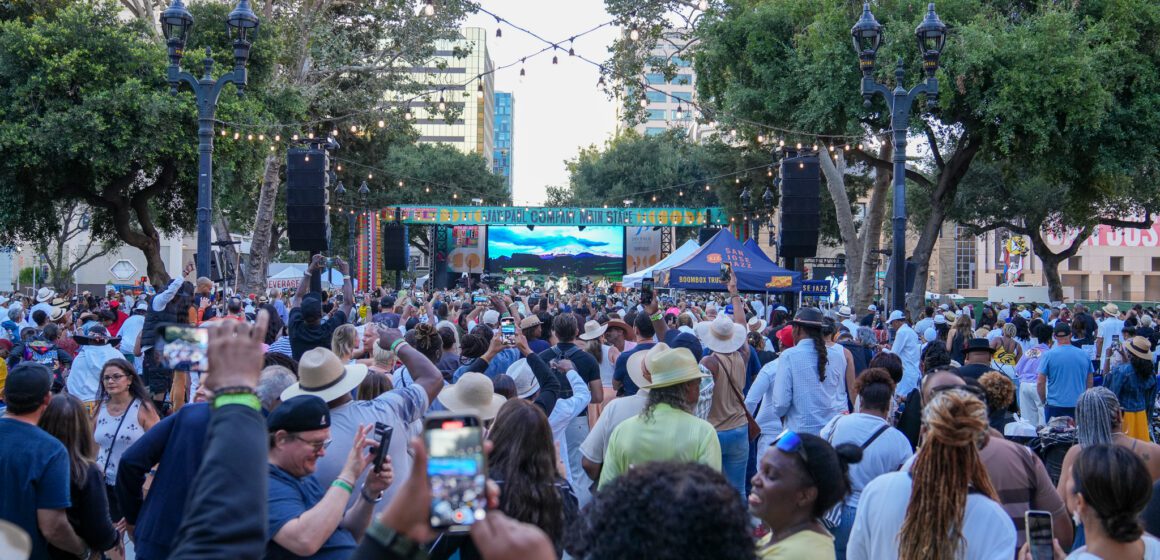 A crowd of people watching an outdoor music performance in San Jose, California