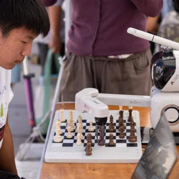 Un estudiante de secundaria juega al ajedrez con un robot en una exhibición tecnológica en Mountain View, California.