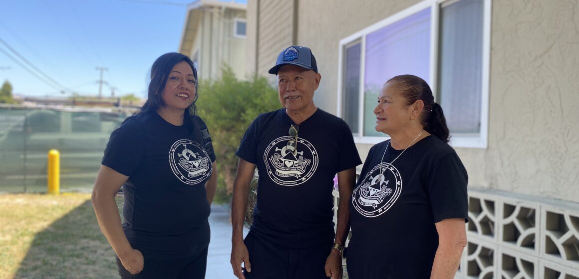 Three people standing in front of an apartment complex in San Jose, California