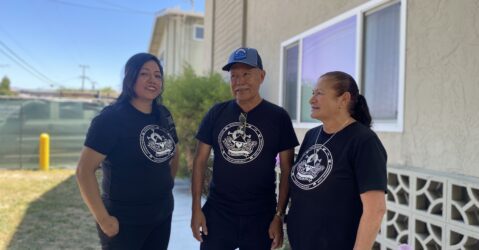 Three people standing in front of an apartment complex in San Jose, California
