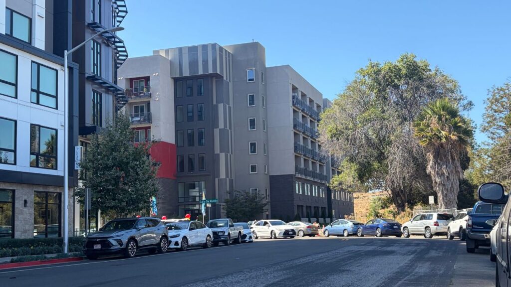 Cars parked on a street outside an apartment building in Santa Clara, California