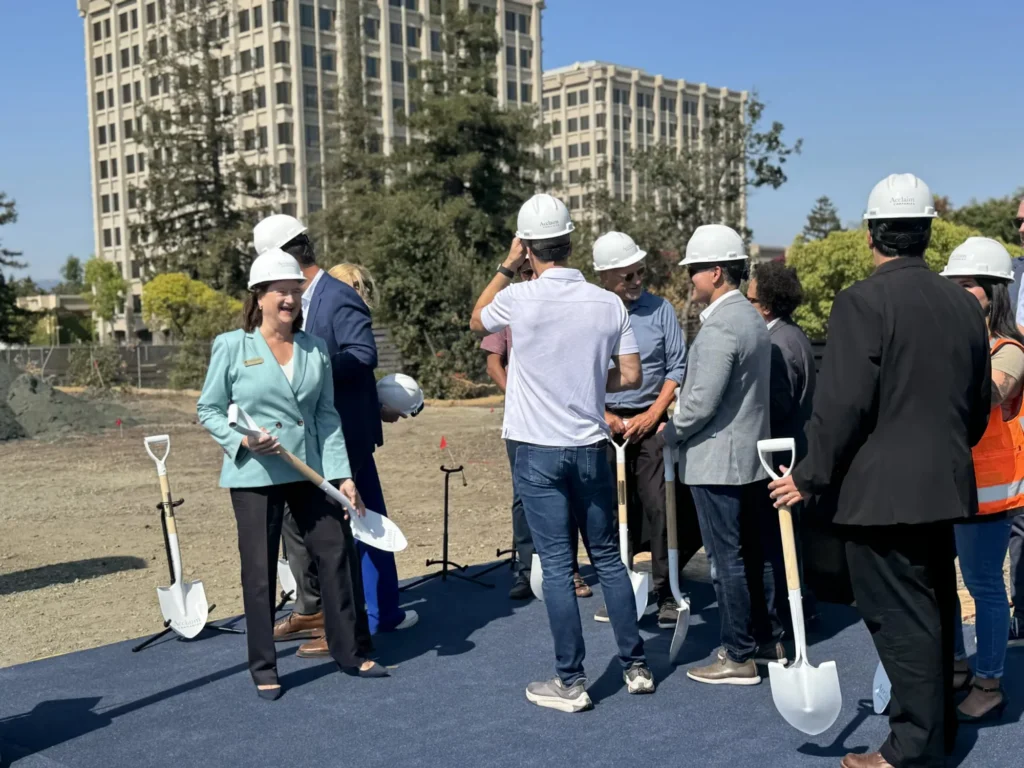 People with hard hats and shovels at a development site in Palo Alto, California