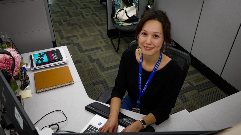 A woman sitting at a desk with a keyboard