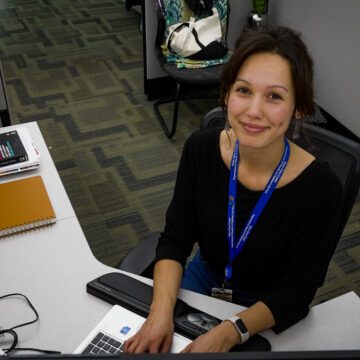 A woman sitting at a desk with a keyboard