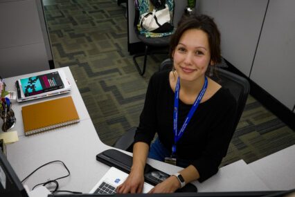 A woman sitting at a desk with a keyboard