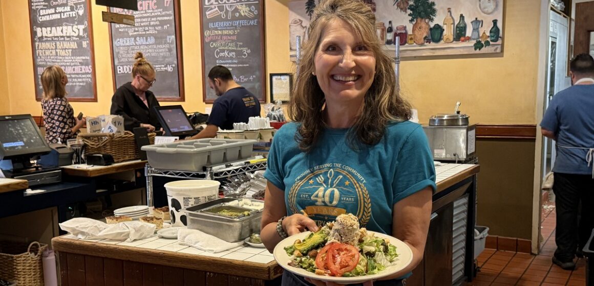 A woman standing in a restaurant with a plate of food in Sunnyvale, California