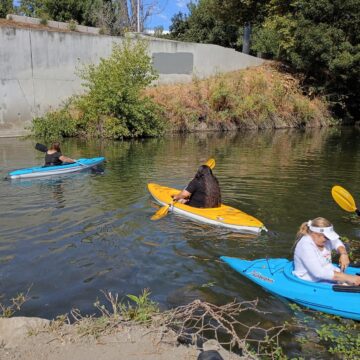 People in kayaks floating on a river in San Jose, California