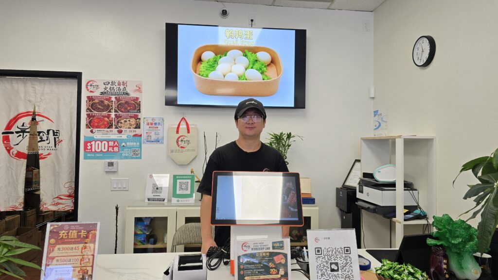 Một người đàn ông đứng sau quầy hàng tại một khu chợ ở San Jose, California.
