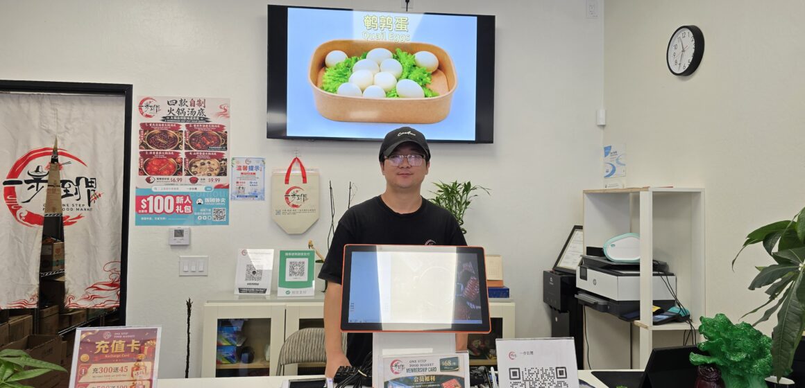 One Step Market Owner (Yaodong Guo) A man behind a counter at a market in San Jose, California