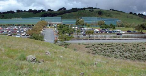 A grass hil in front of a parking lot in San Jose, California