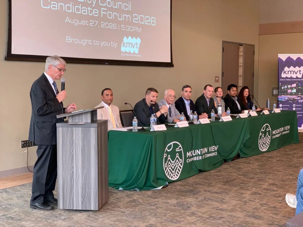 A group of people sitting at a long table at a candidate forum in Mountain View, California