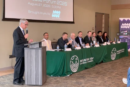 A group of people sitting at a long table at a candidate forum in Mountain View, California
