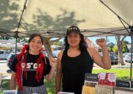 A man and woman standing under a canopy with their fists raised in the air in San Jose, California
