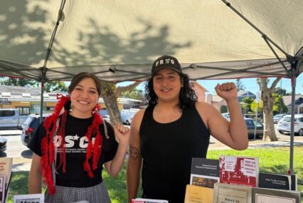 A man and woman standing under a canopy with their fists raised in the air in San Jose, California