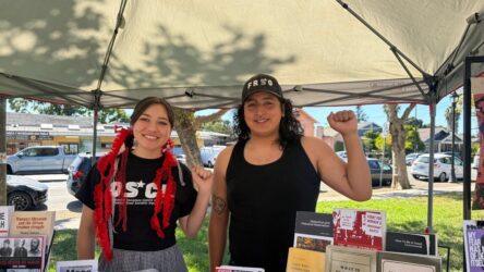 A man and woman standing under a canopy with their fists raised in the air in San Jose, California