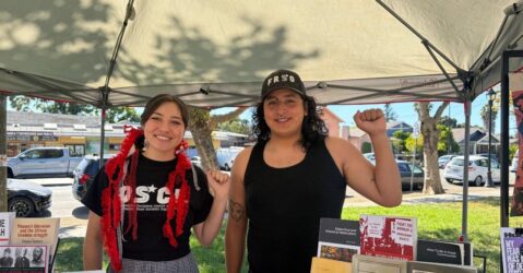 A man and woman standing under a canopy with their fists raised in the air in San Jose, California